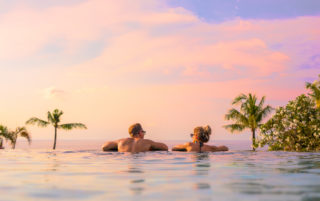 Couple in infinity pool sunset