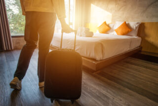 Cropped shot of tourist woman pulling her luggage to her hotel bedroom after check in.